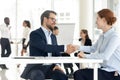 Smiling diverse business partners handshake closing deal at meeting Royalty Free Stock Photo