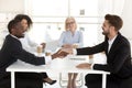 Diverse businessmen shake hands closing deal after negotiation