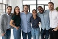 Smiling diverse business people hugging, standing in modern office Royalty Free Stock Photo