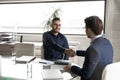 Smiling diverse businessmen making deal, satisfied with negotiations results.