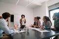 Smiling diverse colleagues gather in boardroom brainstorm discuss financial statistics together Royalty Free Stock Photo