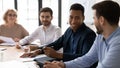 Smiling diverse colleagues joke discussing ideas at meeting Royalty Free Stock Photo