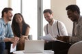 Smiling diverse colleagues laugh cooperating at briefing in office Royalty Free Stock Photo