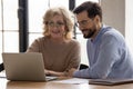 Smiling diverse colleagues work on laptop at meeting Royalty Free Stock Photo