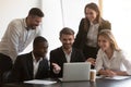 Smiling diverse employees cooperating in office using laptop Royalty Free Stock Photo