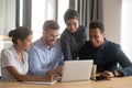 Smiling diverse employees laugh cooperating at laptop in office Royalty Free Stock Photo