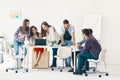 Smiling diverse group of young people working and communicating together in office Royalty Free Stock Photo