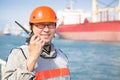 Smiling dock worker holding radio