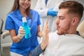 Smiling Doctor dentist showing patient`s mouthwash Royalty Free Stock Photo