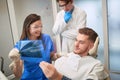 .Smiling Doctor dentist showing patient`s teeth on X-ray Royalty Free Stock Photo