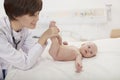 Smiling doctor examining a baby in the doctors office Royalty Free Stock Photo