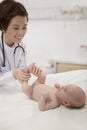 Smiling doctor examining a baby in the doctors office Royalty Free Stock Photo