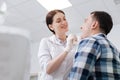 Smiling doctor examining sore throat Royalty Free Stock Photo