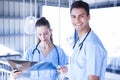 Smiling doctor examining a x ray report with his colleague Royalty Free Stock Photo