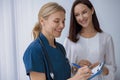 Smiling doctor fills out the medical report form on medical care of patients during appointment Royalty Free Stock Photo