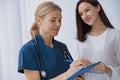 Smiling doctor fills out the medical report form on medical care of patients during appointment Royalty Free Stock Photo