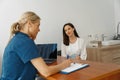 Smiling doctor fills out the medical report form on medical care of patients during appointment Royalty Free Stock Photo