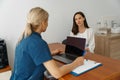 Smiling doctor fills out the medical report form on medical care of patients during appointment Royalty Free Stock Photo