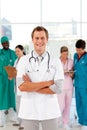 Smiling doctor with his team in the background Royalty Free Stock Photo