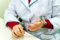 Smiling doctor holding reflex hammer toward camera, focus on the foreground, on the hammer. Royalty Free Stock Photo