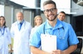 Smiling doctor holding tablet in front of his medical team Royalty Free Stock Photo