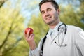 Smiling doctor keeping an apple in hand