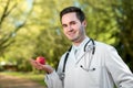 Smiling doctor keeping an apple in hand