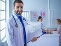 Smiling doctor man standing in front of his team and patient Royalty Free Stock Photo