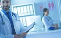 Smiling doctor man standing in front of his team and patient Royalty Free Stock Photo