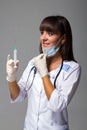 Smiling doctor with mask, stethoscope and syringe Royalty Free Stock Photo