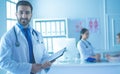 Smiling doctor man standing in front of his team and patient Royalty Free Stock Photo