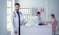 Smiling doctor man standing in front of his team and patient Royalty Free Stock Photo