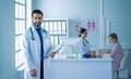 Smiling doctor man standing in front of his team and patient Royalty Free Stock Photo