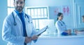 Smiling doctor man standing in front of his team and patient Royalty Free Stock Photo