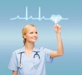Smiling doctor or nurse pointing to cardiogram