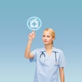 Smiling doctor or nurse pointing to hospital icon