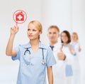 Smiling doctor or nurse pointing to hospital icon