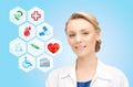 Smiling doctor over medical icons blue background Royalty Free Stock Photo