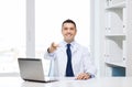 Smiling doctor pointing finger at you in office Royalty Free Stock Photo