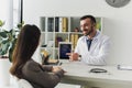 smiling doctor pointing on ipad to patient