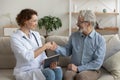 Smiling doctor and senior patient handshake during medical homecare visit Royalty Free Stock Photo