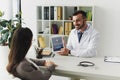 smiling doctor showing tablet with loaded tumblr page to patient