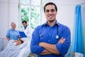 Smiling doctor standing with arms crossed in hospital Royalty Free Stock Photo