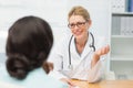 Smiling doctor talking to her patient