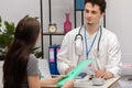 A smiling doctor talks to a young patient in a doctor& x27;s office. General practitioner Royalty Free Stock Photo