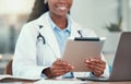 Smiling doctor using a digital tablet. African american doctor using a wireless tablet in the hospital. Medical gp Royalty Free Stock Photo