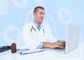 Smiling doctor using laptop at desk Royalty Free Stock Photo