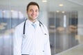 Smiling doctor waiting for his team while standing upright