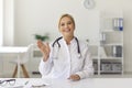 Smiling doctor waving hand starting video call with patient or recording medical vlog Royalty Free Stock Photo