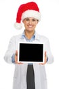 Smiling doctor woman in santa hat showing tablet pc blank screen Royalty Free Stock Photo